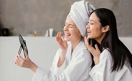 Zwei Freundinnen umarmen sich und lachen 