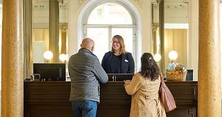 Empfang im historischen Gebäude mit Gästen und einem Teammitglied