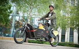 Mann faehrt mit Carvelo und Kind 