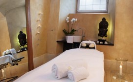 Massageliege in der Wellnessoase mit schöner Dekoration und Spiegel im Hintergrund